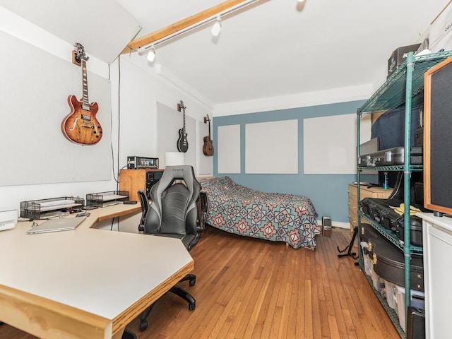 bedroom with light wood finished floors and track lighting