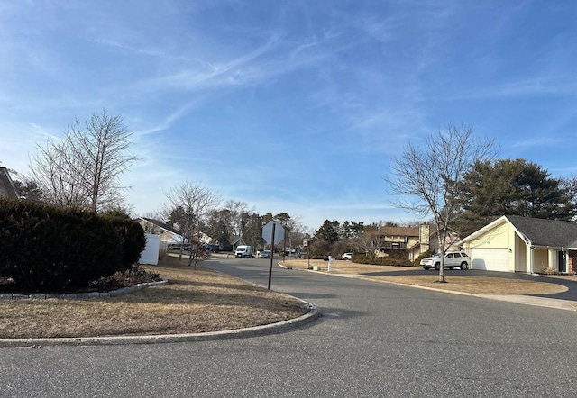 view of street with traffic signs, a residential view, and curbs