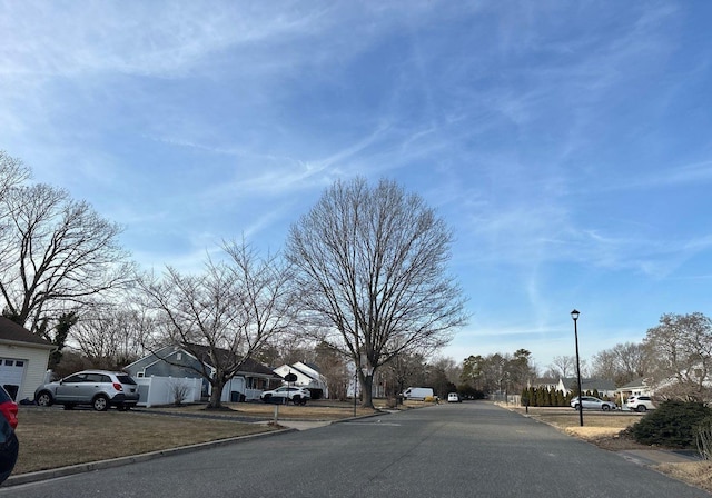 view of road featuring street lighting, a residential view, and curbs