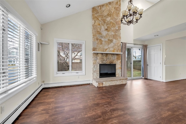 unfurnished living room featuring a fireplace, baseboard heating, a wealth of natural light, and wood finished floors