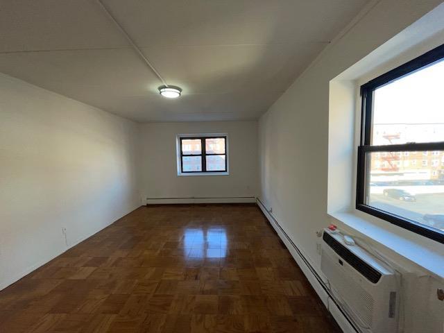 unfurnished room with a baseboard heating unit