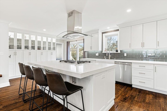 kitchen featuring a kitchen island, dark wood finished floors, island exhaust hood, a sink, and stainless steel appliances