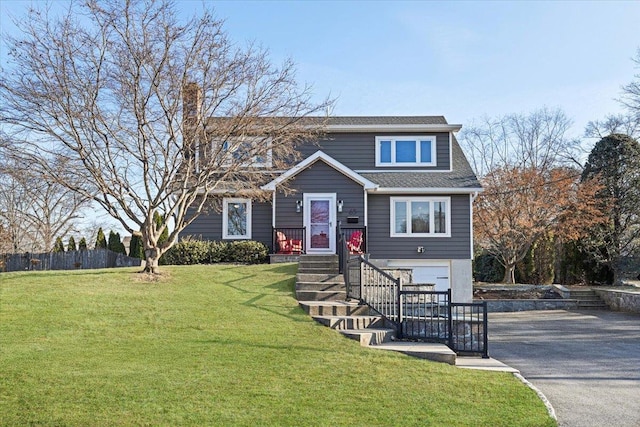 view of front of home featuring aphalt driveway, an attached garage, roof with shingles, and a front lawn