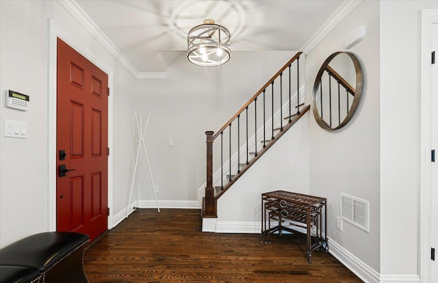 entryway with visible vents, baseboards, wood finished floors, and ornamental molding