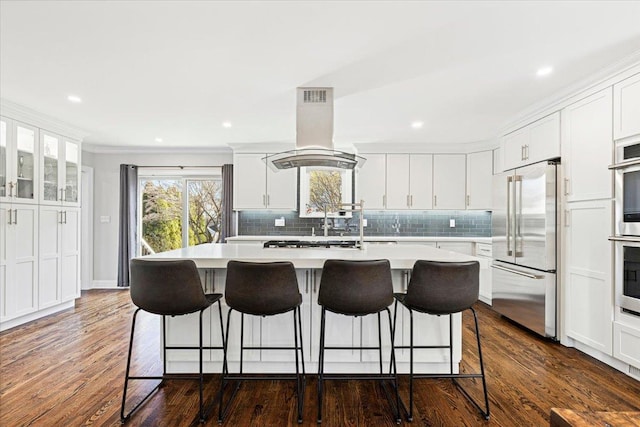 kitchen with appliances with stainless steel finishes, white cabinets, island range hood, and light countertops