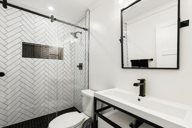 bathroom with a stall shower, toilet, crown molding, and vanity