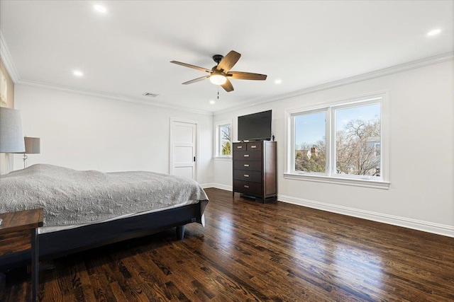 bedroom with visible vents, baseboards, dark wood finished floors, and ornamental molding