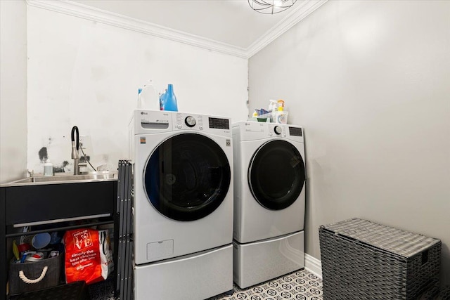 laundry area with a sink, ornamental molding, laundry area, and washer and clothes dryer