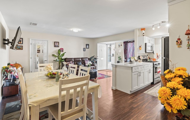 dining space featuring dark wood-type flooring and visible vents