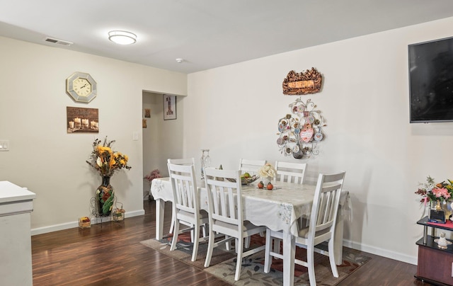 dining room featuring visible vents, baseboards, and wood finished floors