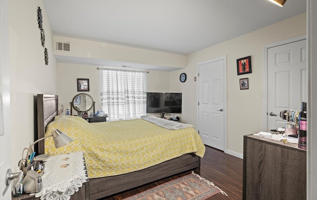 bedroom with baseboards, visible vents, and dark wood finished floors