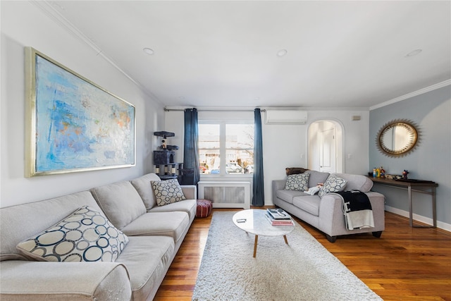 living area featuring a wall unit AC, crown molding, radiator, wood finished floors, and baseboards