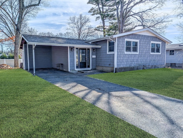 view of front facade featuring driveway, an attached carport, and a front yard