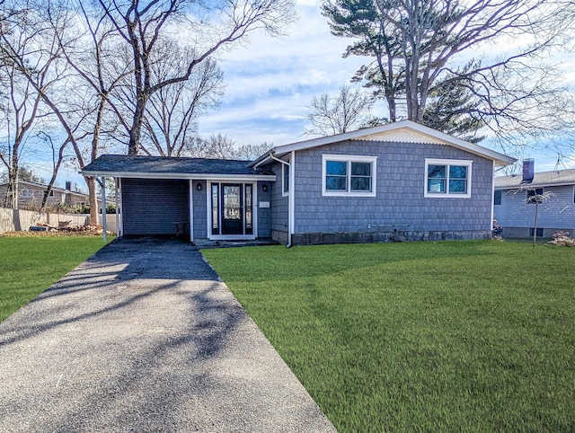 view of front of house featuring driveway, a front lawn, and fence