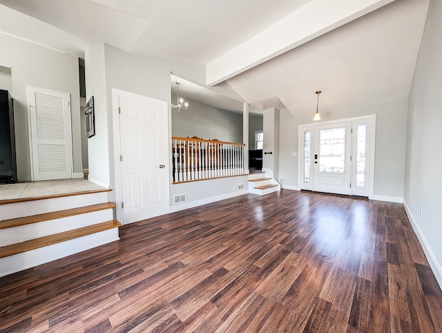 entrance foyer with dark wood-style floors, vaulted ceiling with beams, a notable chandelier, visible vents, and stairs