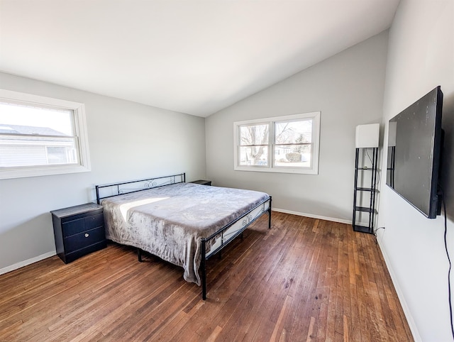 bedroom with baseboards, vaulted ceiling, and dark wood finished floors