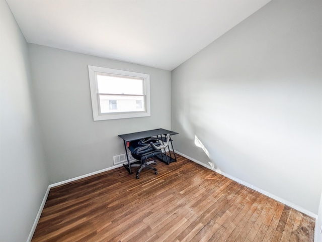 spare room with visible vents, baseboards, and wood finished floors