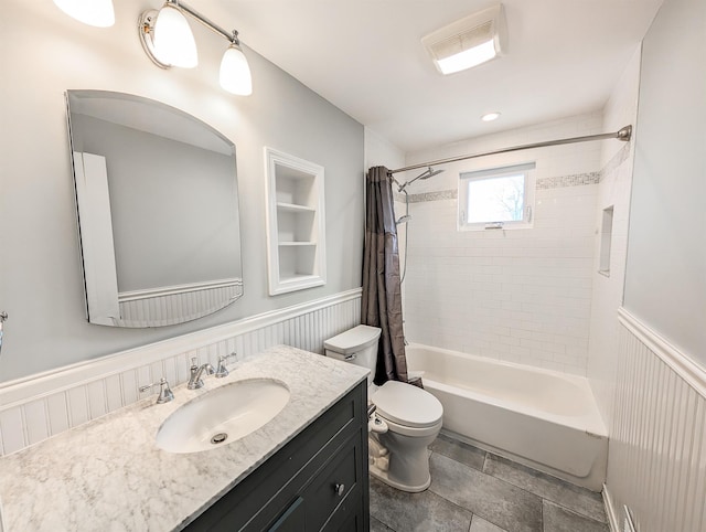 bathroom with shower / tub combo, a wainscoted wall, vanity, and toilet