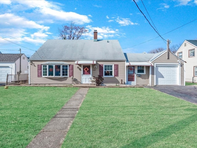 view of front of property featuring a front yard, an attached garage, a chimney, and aphalt driveway