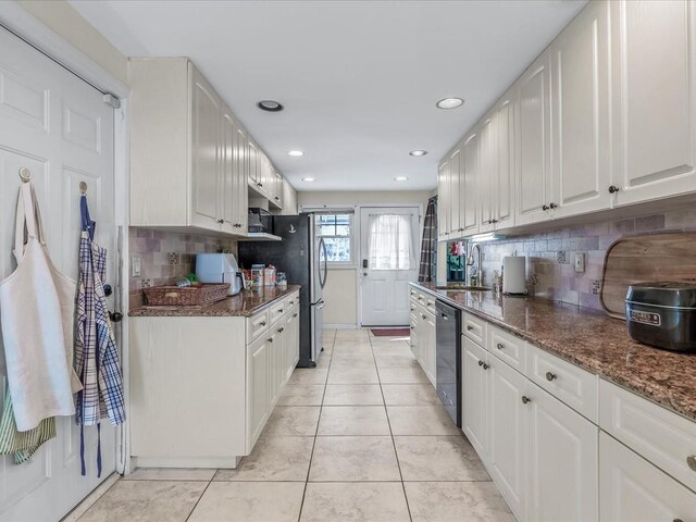 kitchen featuring dark stone counters, a sink, decorative backsplash, dishwasher, and recessed lighting