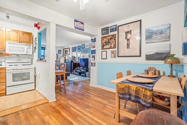 dining room featuring ceiling fan, light wood-type flooring, and baseboards