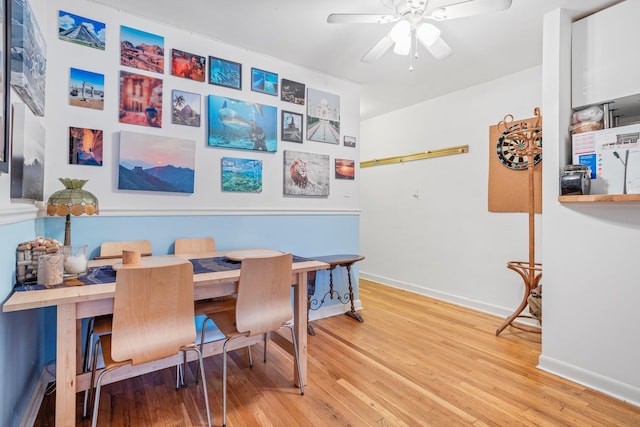 dining area featuring light wood-style floors, baseboards, and a ceiling fan