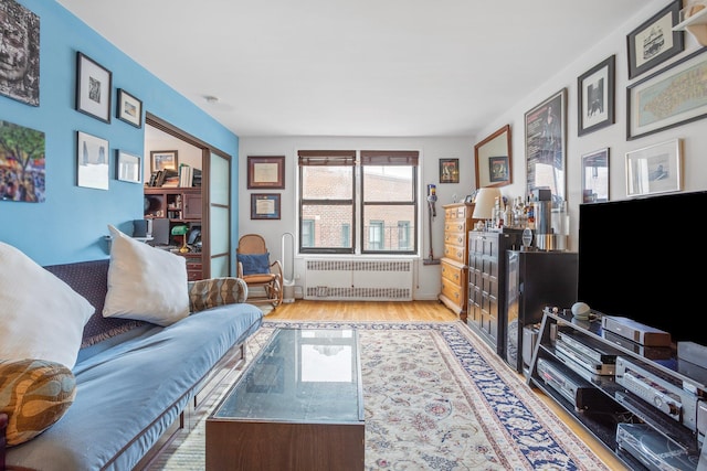 living area with light wood-style floors and radiator heating unit