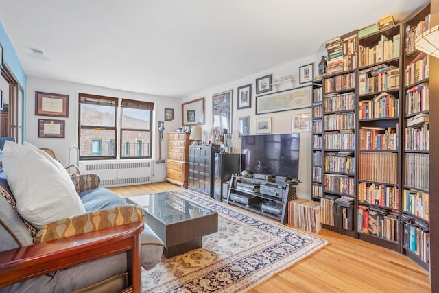 living room featuring light wood-style flooring and radiator