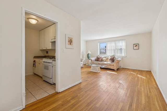 living area with light wood-style flooring and baseboards