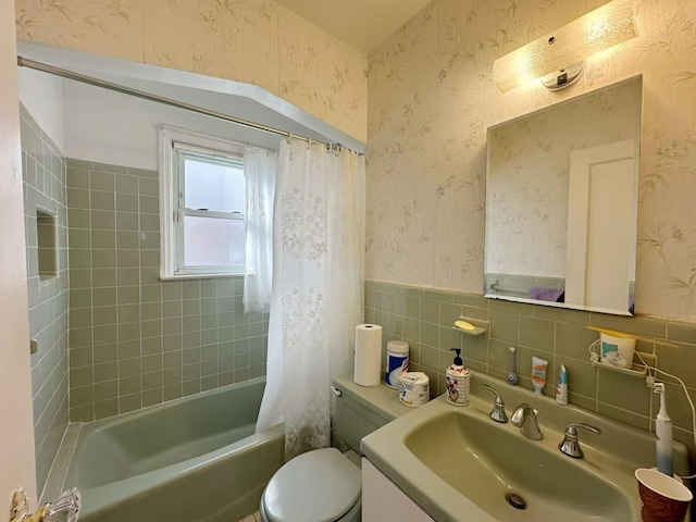 bathroom with shower / bath combo, a wainscoted wall, toilet, and wallpapered walls