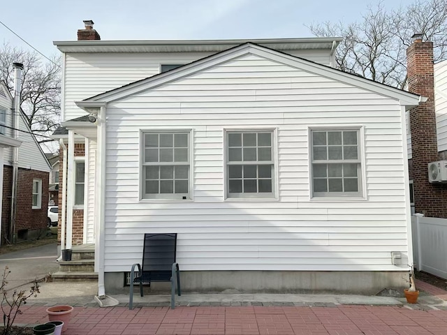 view of side of home with a patio area and a chimney