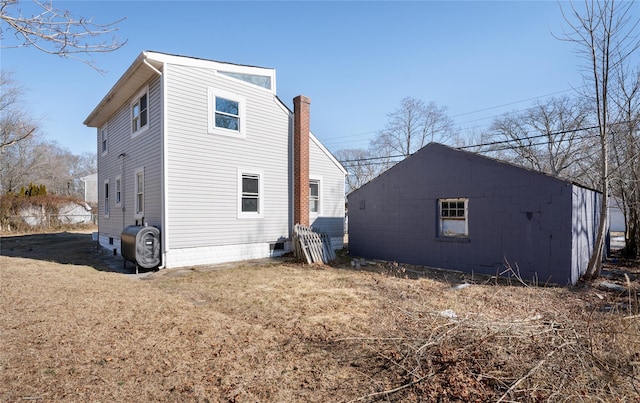 rear view of house with a chimney and heating fuel