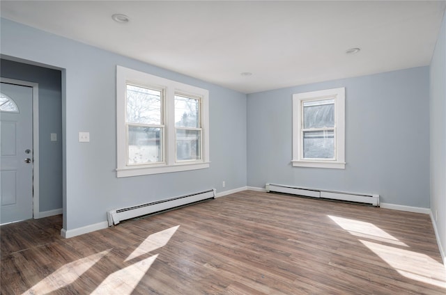 entrance foyer featuring baseboards, baseboard heating, and wood finished floors