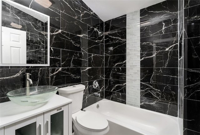 bathroom featuring toilet, vanity, tile walls, shower / bathing tub combination, and tasteful backsplash