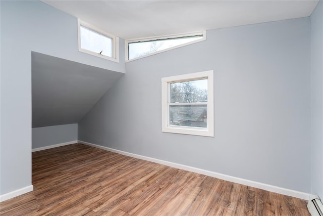 bonus room with vaulted ceiling, a baseboard radiator, wood finished floors, and baseboards