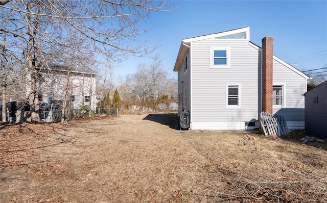 view of side of property with driveway and a chimney