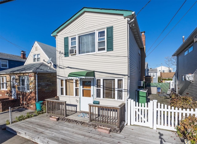 rear view of property featuring fence and a wooden deck