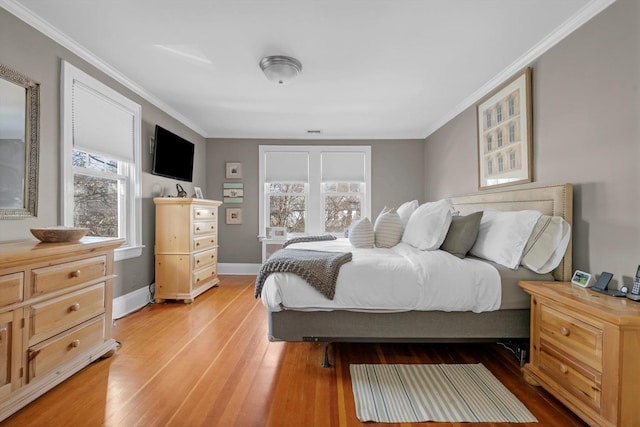 bedroom featuring wood-type flooring, ornamental molding, and baseboards