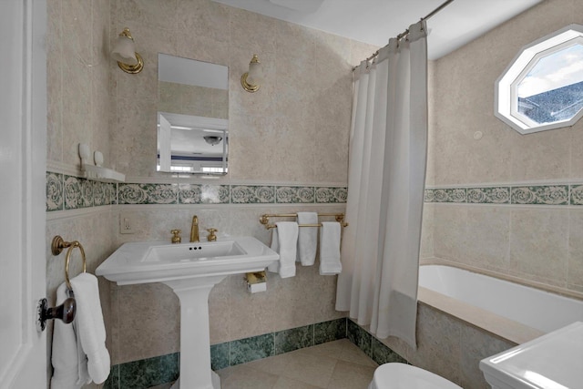 bathroom featuring toilet, shower / bath combo, tile patterned flooring, and tile walls