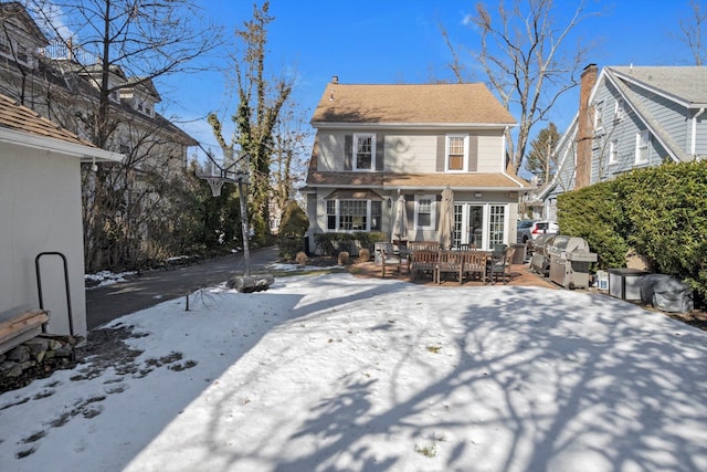 view of snow covered rear of property