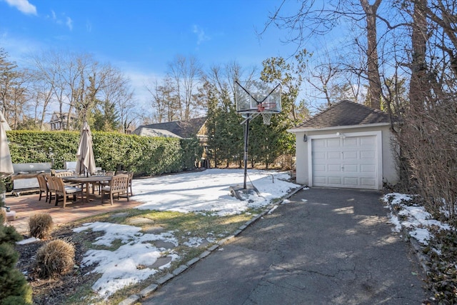 view of patio / terrace featuring an outbuilding, outdoor dining space, and a garage