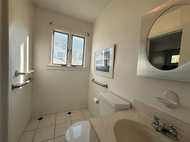 half bath with toilet, tile patterned flooring, baseboards, and vanity