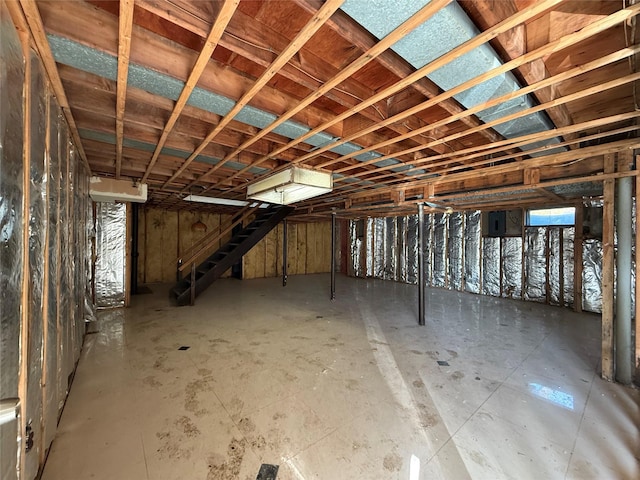 basement featuring electric panel and stairway