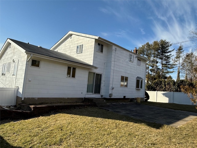 rear view of property with a patio area, a chimney, fence, and a lawn