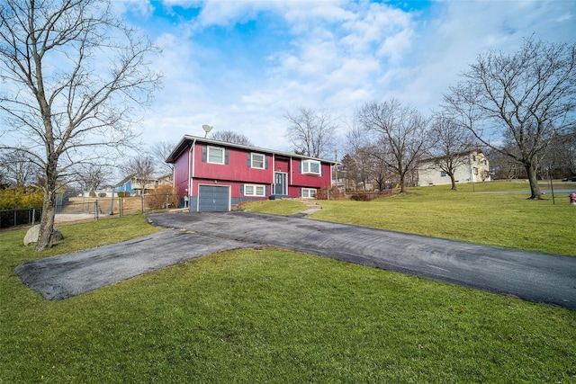 view of front of house featuring aphalt driveway, a garage, a front lawn, and fence