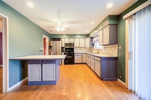 kitchen with a sink, light countertops, tasteful backsplash, and stainless steel appliances