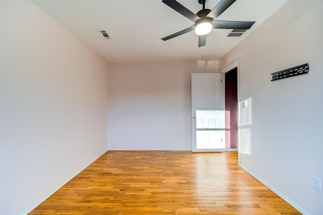 spare room featuring visible vents, a ceiling fan, and light wood finished floors