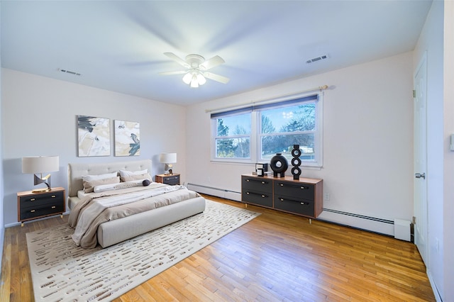 bedroom featuring wood-type flooring, visible vents, and baseboard heating