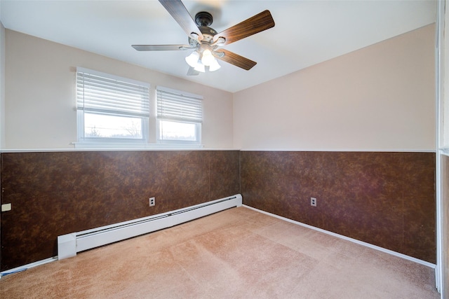 unfurnished room with baseboard heating, wainscoting, carpet flooring, and ceiling fan