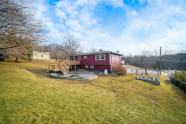 rear view of property featuring stairway, fence, a lawn, and a wooden deck